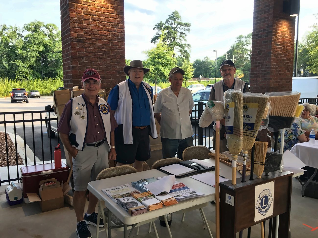 Lexington Lions Club members at their broom sale table with diabetes awareness pamphlets on display.