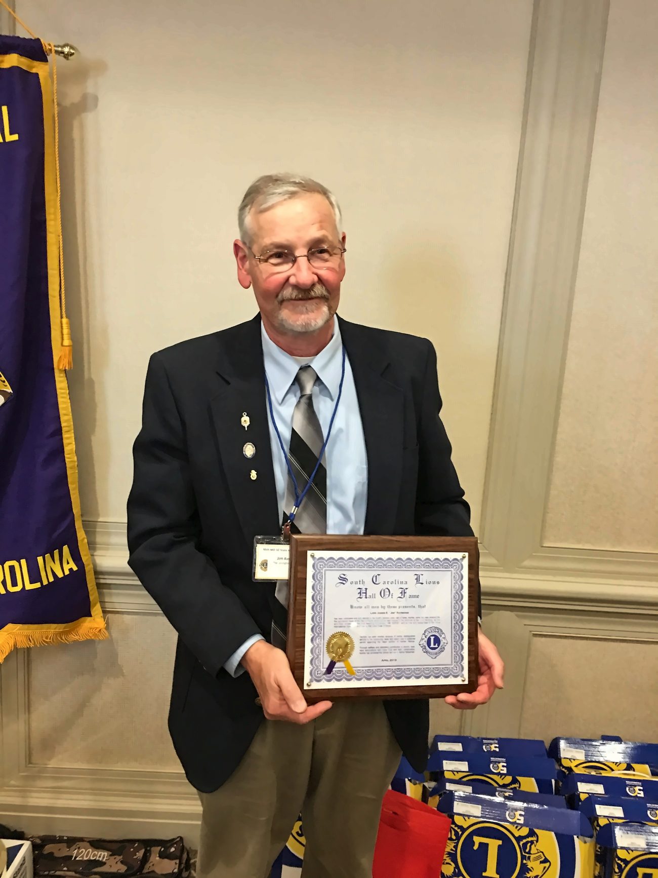 A Lexington Lions Club member holding a South Carolina Lions Hall of Fame plaque.