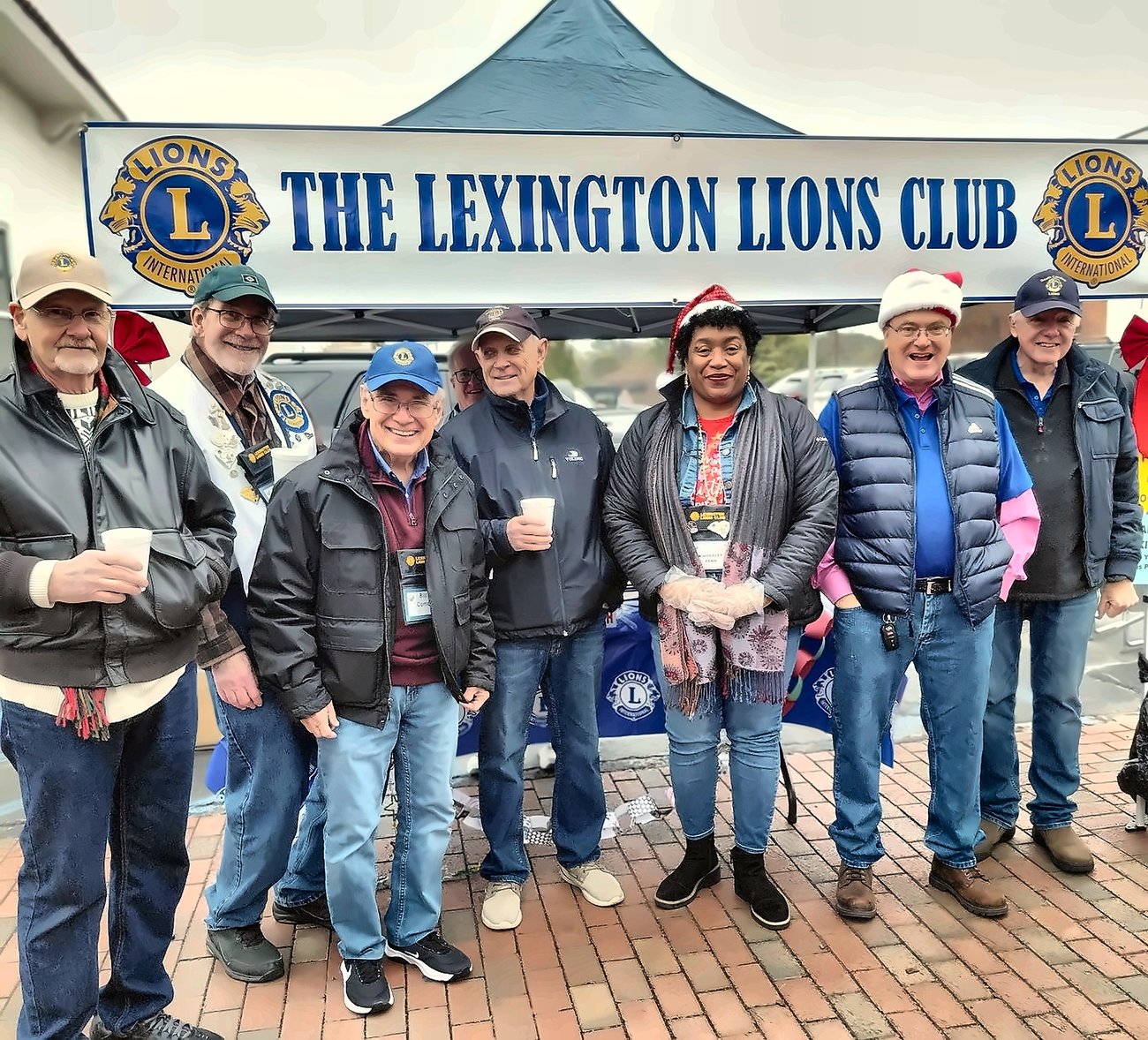 Lexington Lions Club members gathered under their tent at the annual Thanksgiving Christmas parade, serving free hot chocolate to the community.
